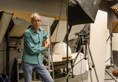 Philip Heying, a photography professor at JCCC, poses in the studio area of the photo lab